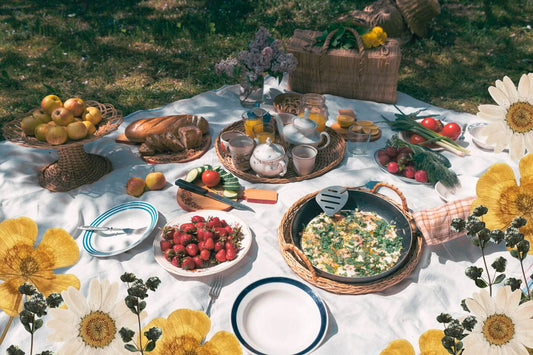 a summer picnic menu on a blanket in the grass