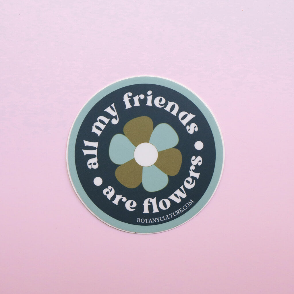 Green, blue, and white circular sticker design with retro flower in middle surrounded by the text "all my friends are flowers"