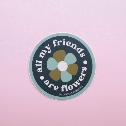 Green, blue, and white circular sticker design with retro flower in middle surrounded by the text "all my friends are flowers"
