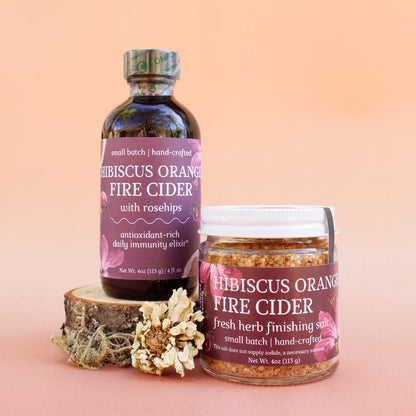 Gift box set of two herbal remedies: 'Hibiscus Orange Fire Cider' and 'Hibiscus Orange Fire Cider Finishing Salt' with decorative herbs and flowers