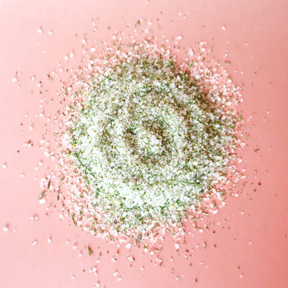 pile of rosemary herbed finishing salt on a pink background