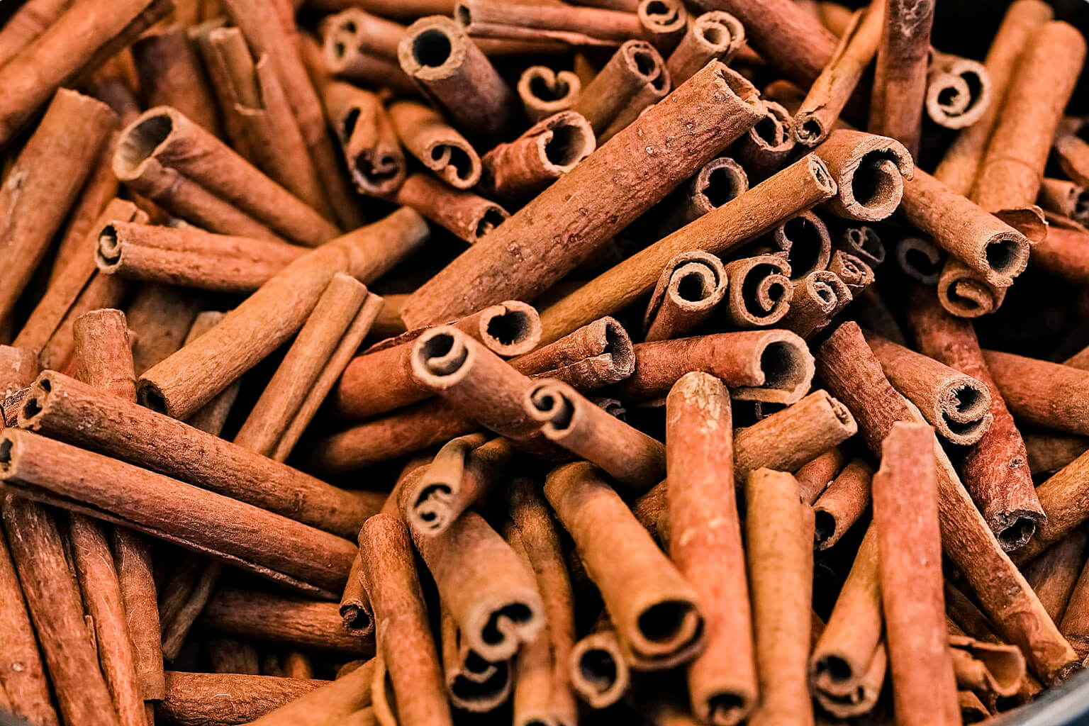 Close-up of cinnamon sticks with a warm brown color.