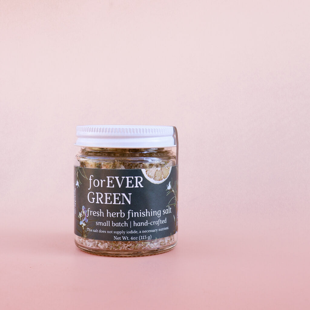Jar of 'Forever Green' fresh herb finishing salt on a pink background