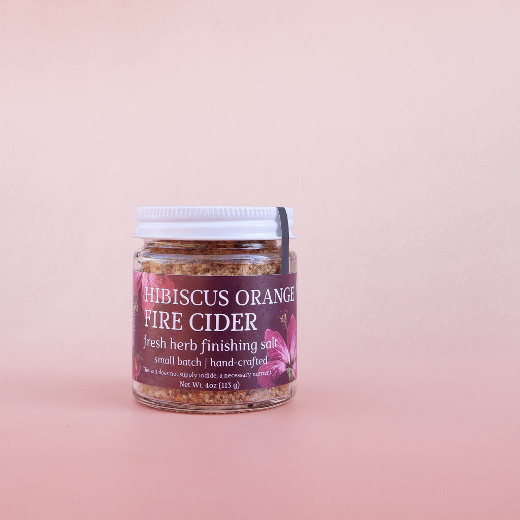 Jar of 'hibiscus orange fire cider finishing salt' on a pink background