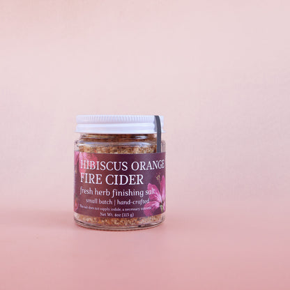 Jar of 'hibiscus orange fire cider finishing salt' on a pink background