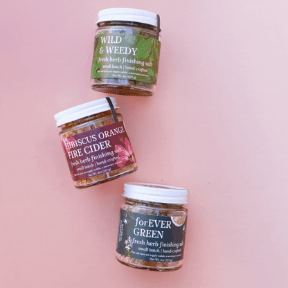 Gif of rotating images of groups of 3 glass jars of fresh herbal finishing salts