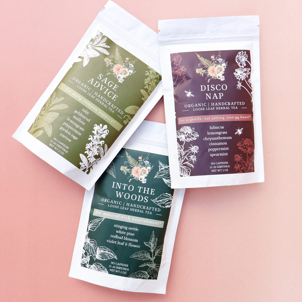 Three organic herbal tea packages on a pink background
