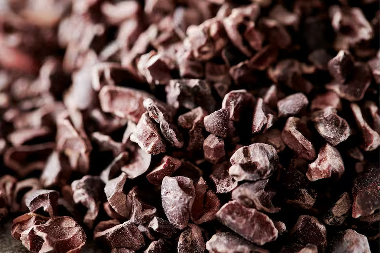 A close-up shot of dark brown cacao nibs