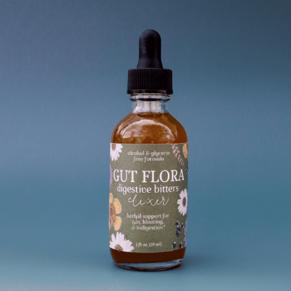 a gif showing a bottle of Gut Flora non-alcoholic dandelion bitters spinning in a circle against a blue background