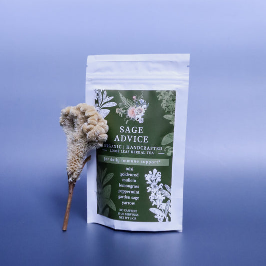bag of Sage Advice Loose-Leaf Herbal Tea against a blue background and a decorative dried flower